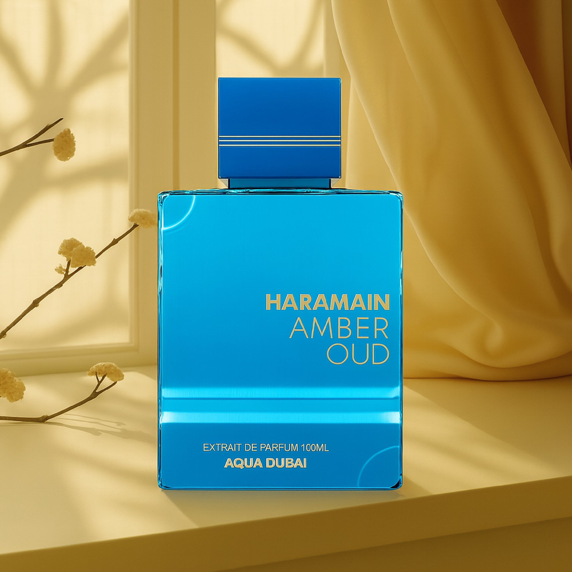 Blue HARAMAIN AMBER OUD perfume bottle on a yellow surface with a blurred background