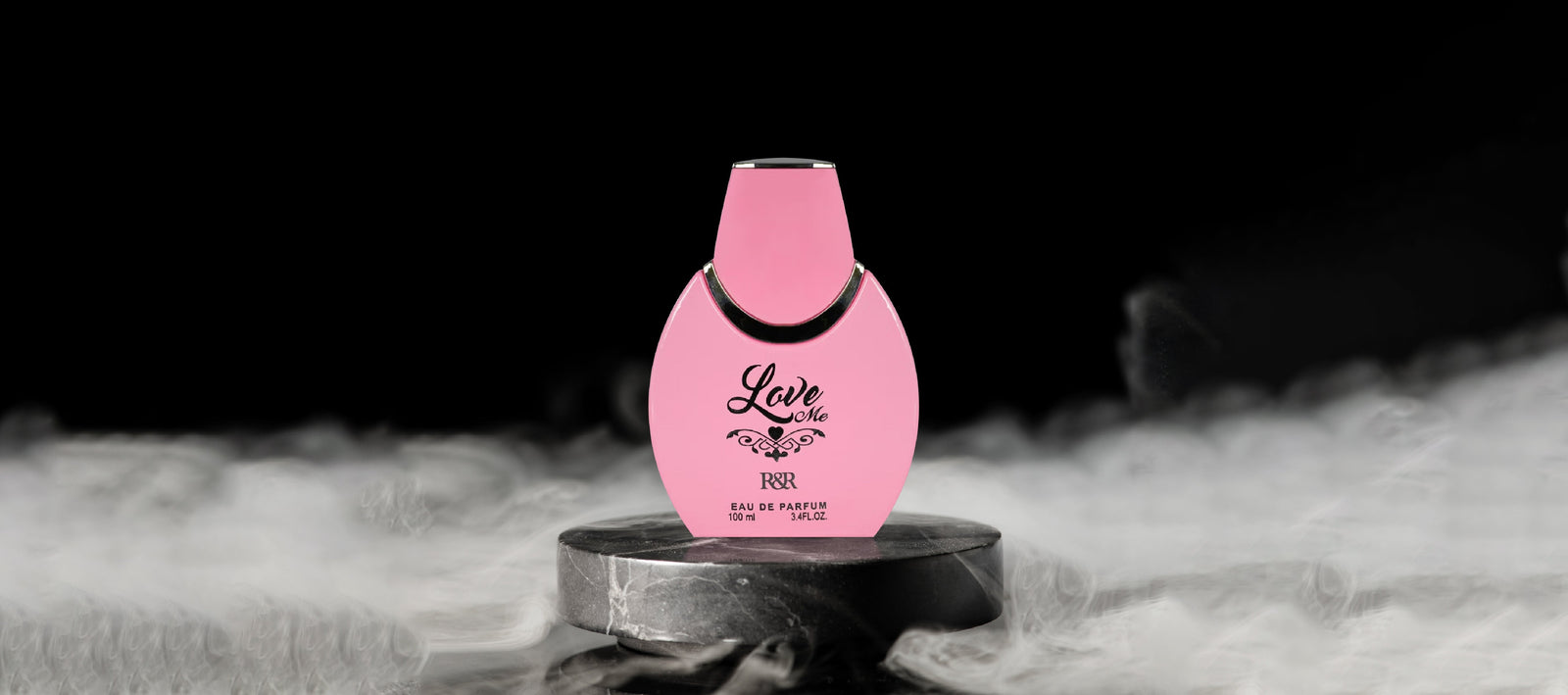 Pink perfume bottle labeled 'Love Me' on a dark background