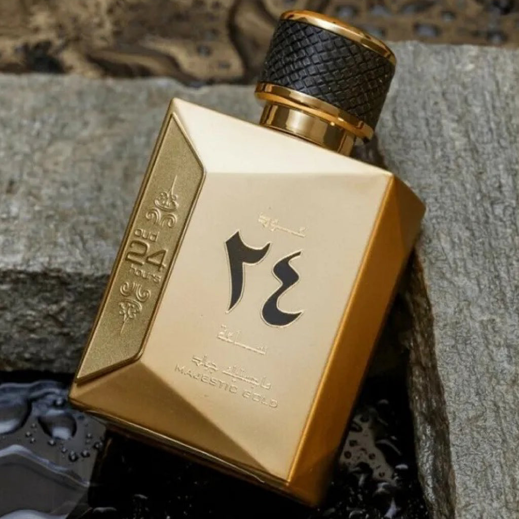 Gold perfume bottle with black cap on a textured surface