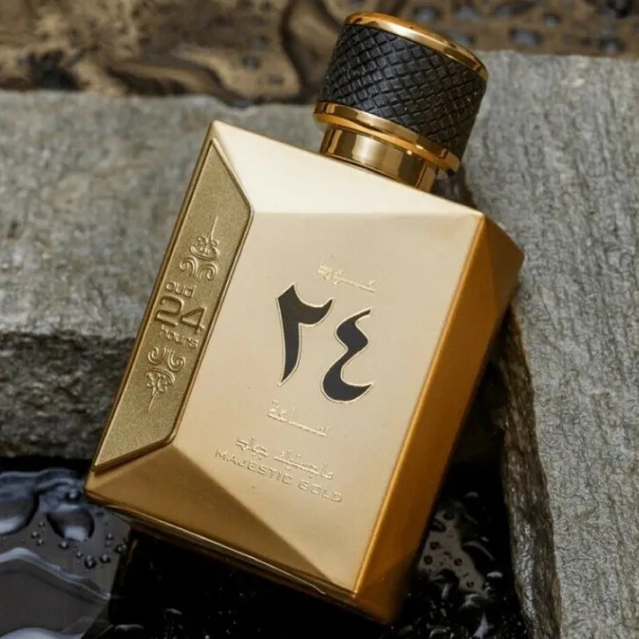 Gold perfume bottle with black cap on a textured surface