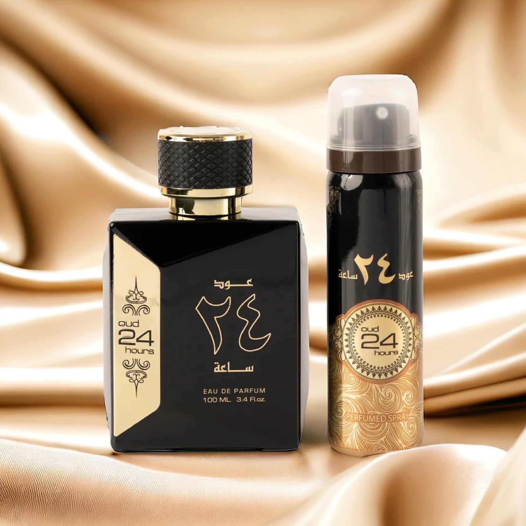 Two perfume bottles, one black and gold and the other black with gold accents, on a beige fabric background.