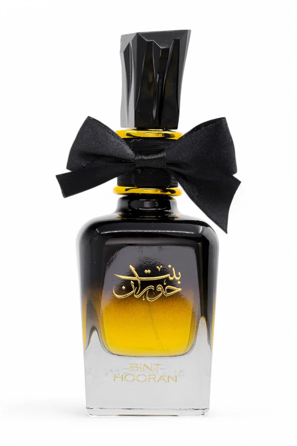 Perfume bottle with black bow and gold accents on a white background