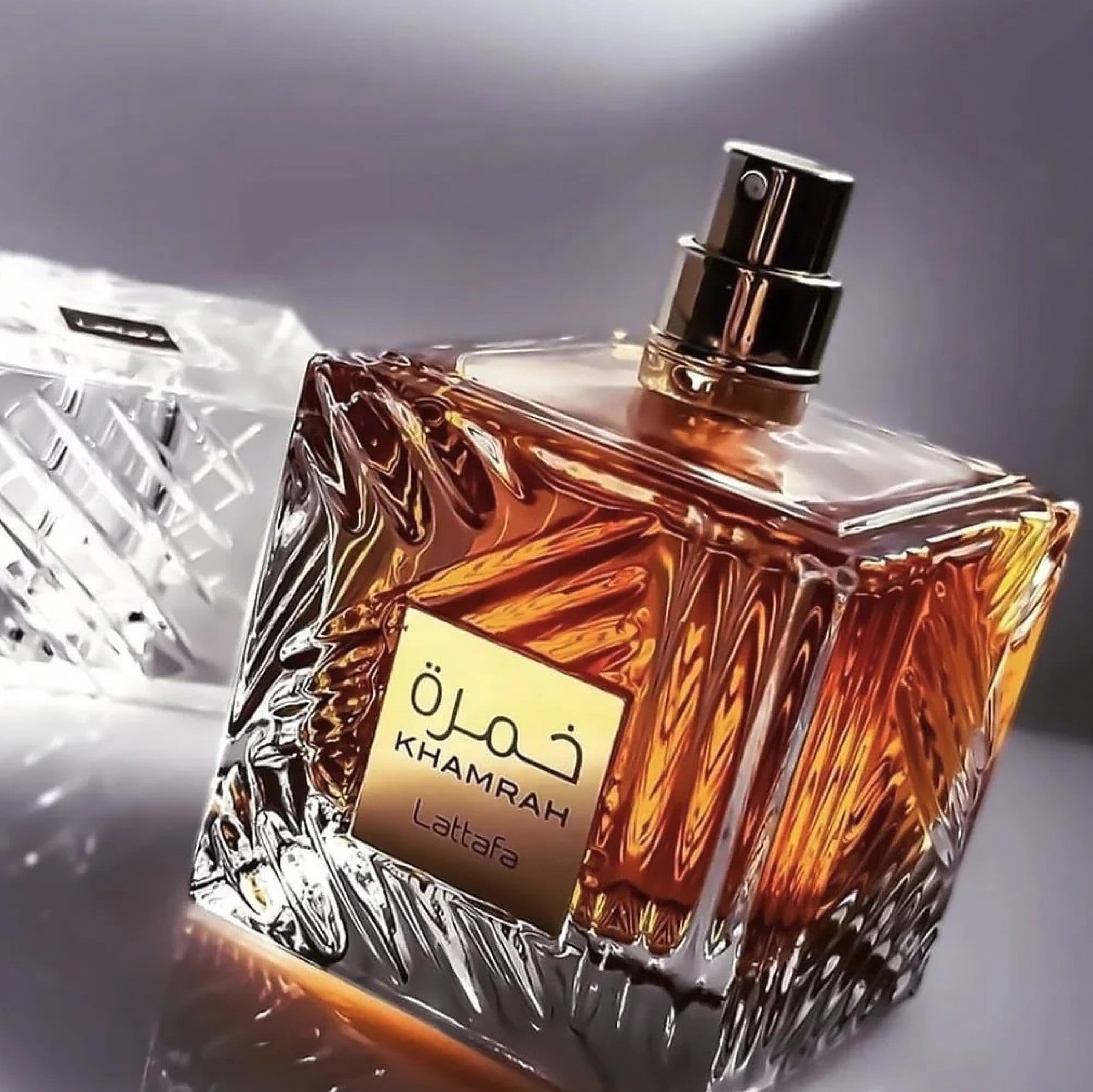 Perfume bottle with 'Khamrah' label on a reflective surface