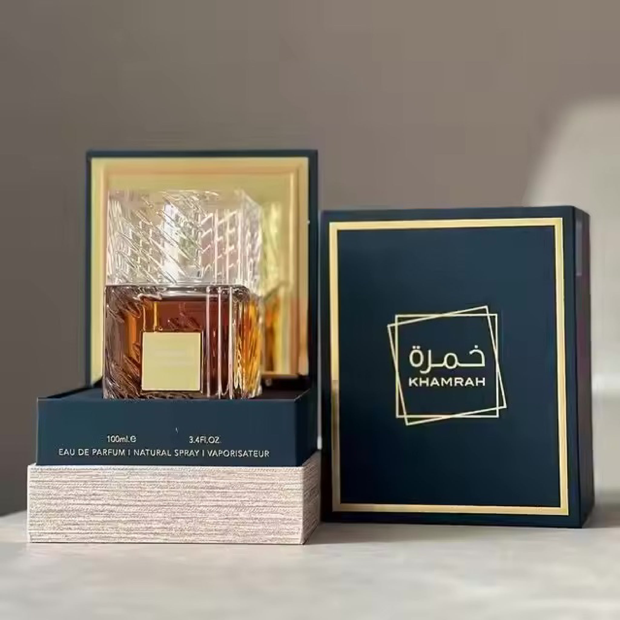 Perfume bottle with packaging and 'Khamrah' branding on a neutral background