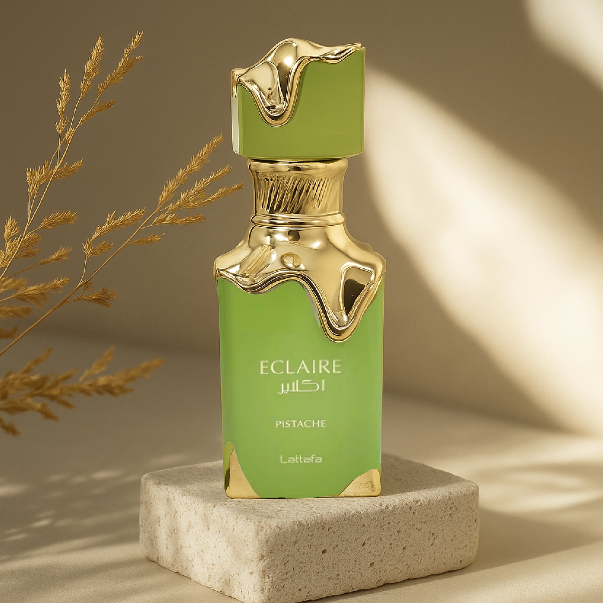 Green and gold perfume bottle labeled 'Eclaire Pistache' on a beige background