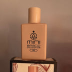 Beige perfume bottle with 'mini brand collection' logo on a wooden stand against a brown background