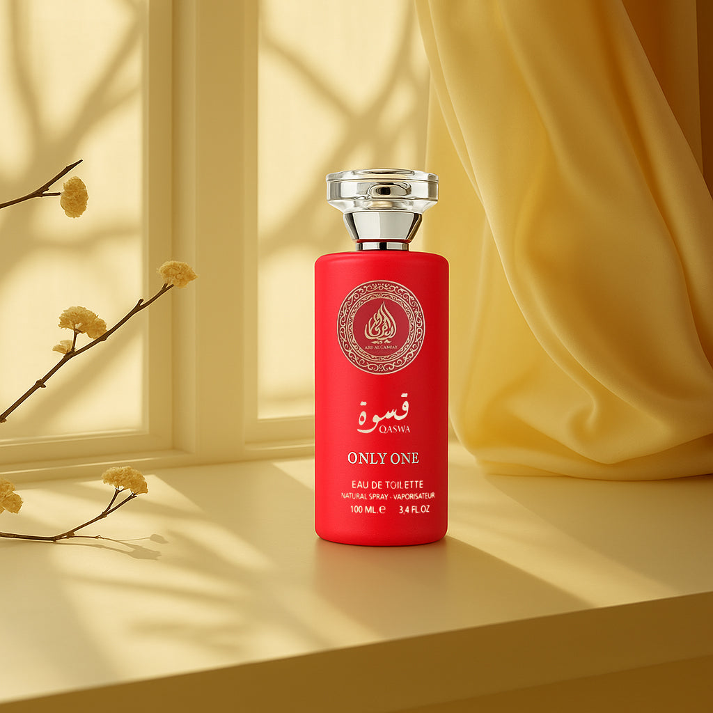 Red perfume bottle with silver cap on a yellow surface with a blurred background