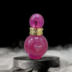 Pink perfume bottle with gold cap on a dark background