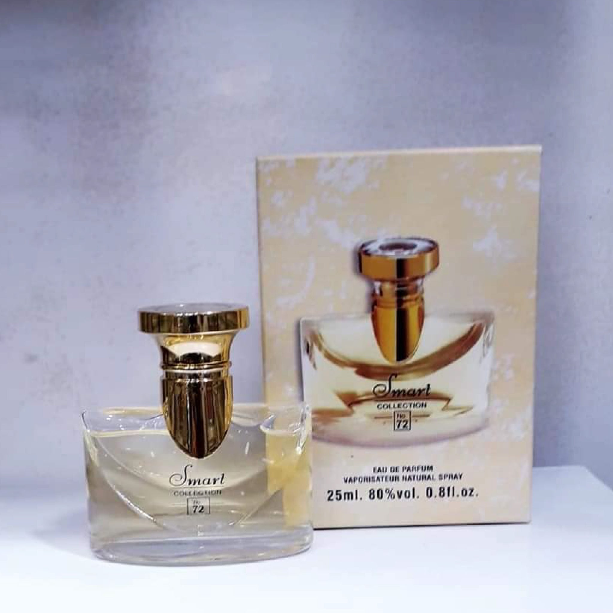 Perfume bottle with gold cap and packaging on a white surface