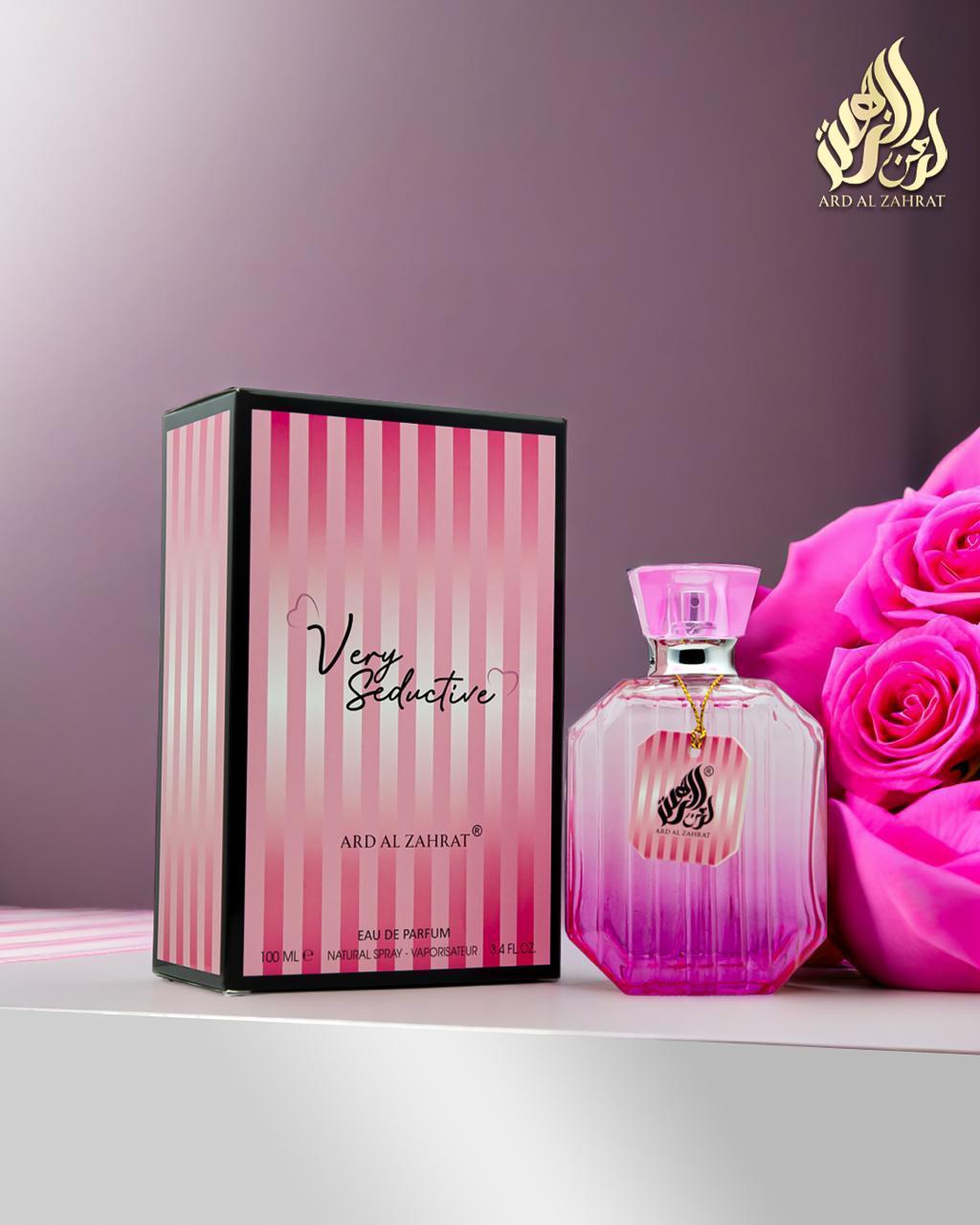 Pink perfume bottle and packaging with roses on a purple background