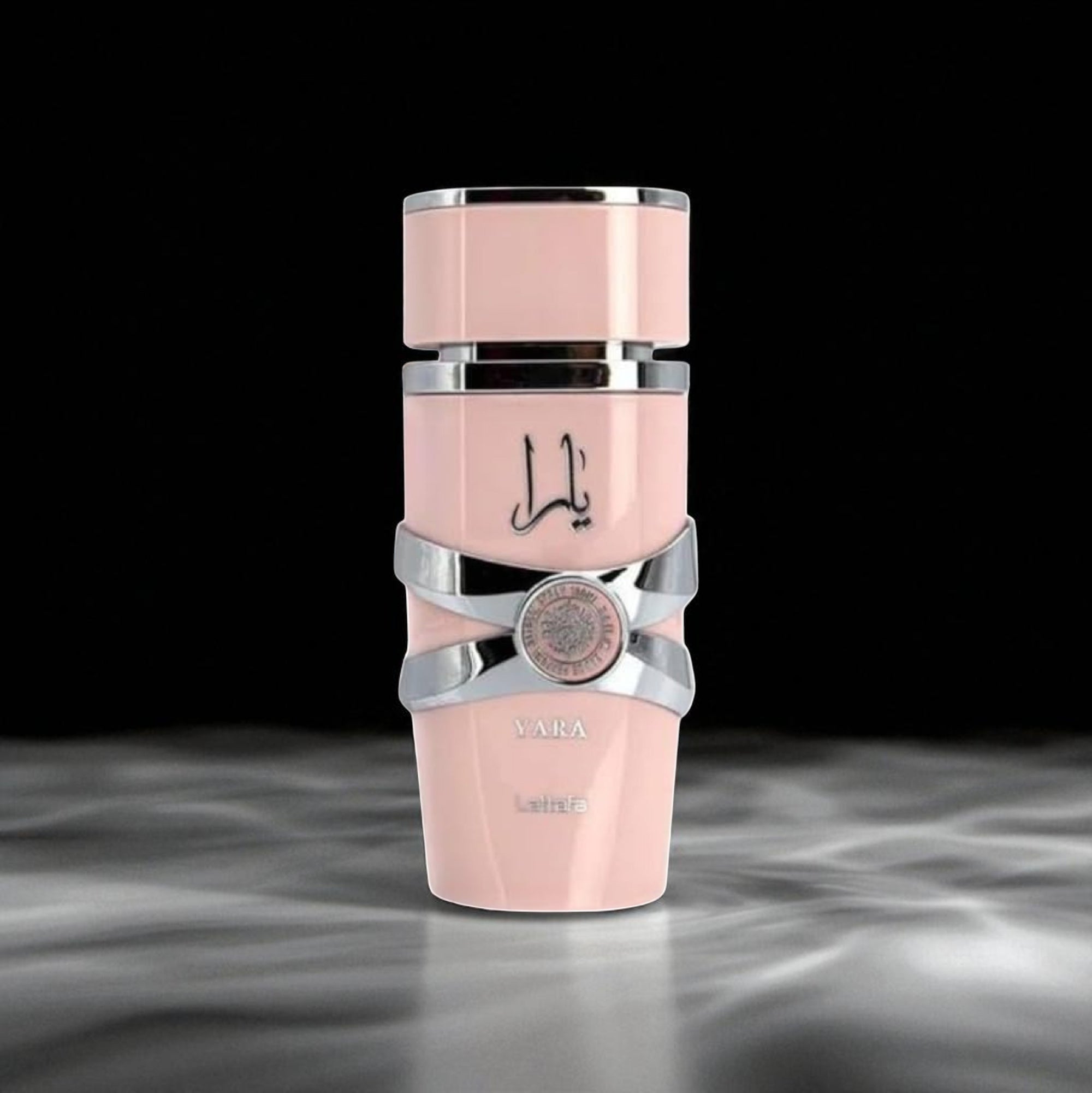 Pink and silver cosmetic bottle with brand logo on a dark background