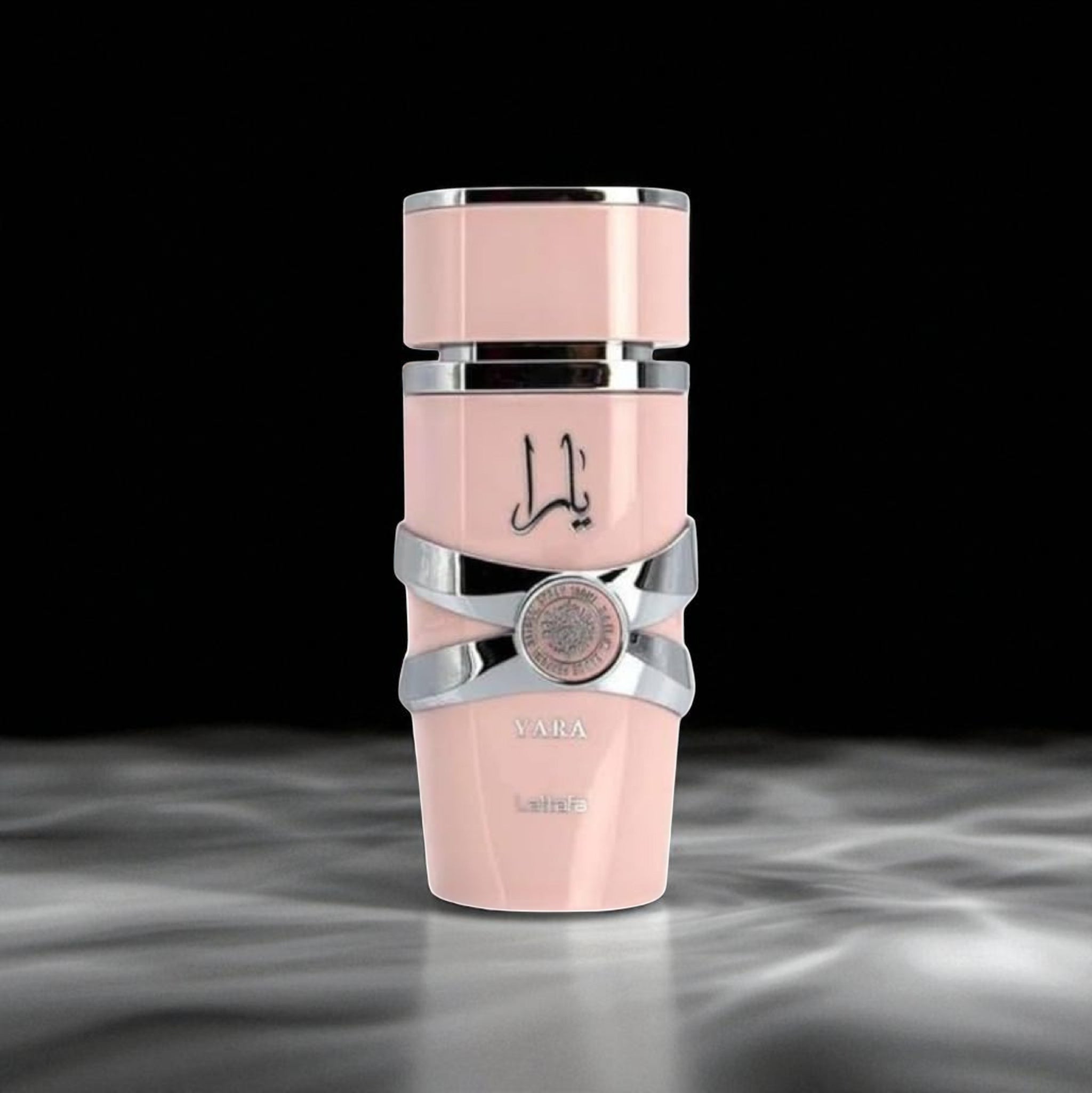 Pink and silver cosmetic bottle with brand logo on a dark background