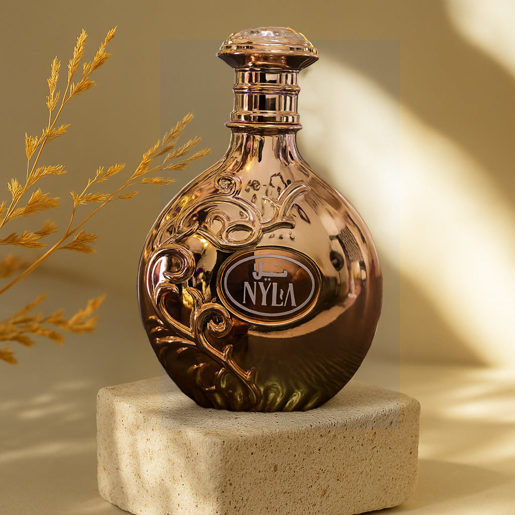 Rose gold bottle with 'J. NYLA' branding on a beige background
