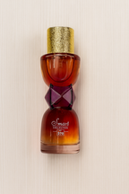 Decorative bottle with a gold cap and intricate design on a beige background